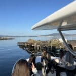 Gente en un barco visitando las bateas de cultivo de mejillones en la Ría de Arousa