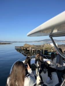 Gente en un barco visitando las bateas de cultivo de mejillones en la Ría de Arousa